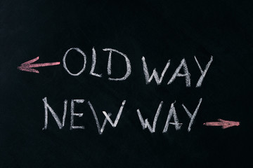 Old Way, New Way written on a blackboard with arrows pointing in the direction of the past and the future. A concept for adapting to change, improvement and development for the self or the business