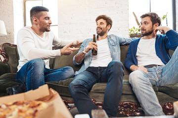Cheerful positive men listening to their friend