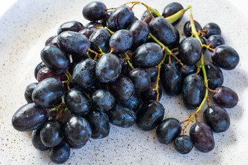 The wet grapes on marble plate