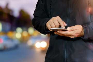 Man using mobile smartphone on night street.