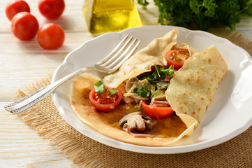 Pancakes sutffed with ham, cheese, tomatoes and mushrooms.