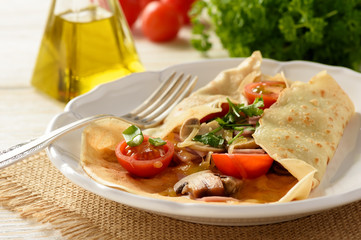 Pancakes sutffed with ham, cheese, tomatoes and mushrooms.