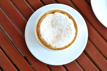 Fototapeta premium Coffee latte or cappuccino in a cup on wooden table