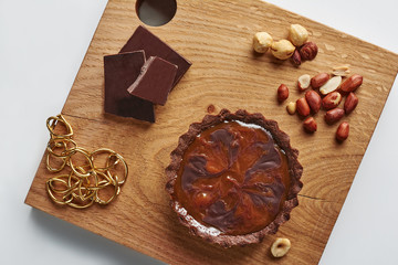 Small Chocolate Tart with huzelnuts and peanut on a white background
