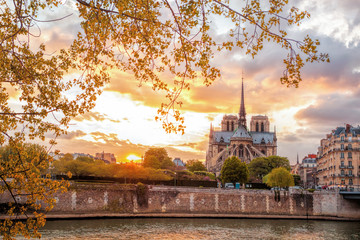 Notre Dame cathedral against colorful sunset during spring time in Paris, France