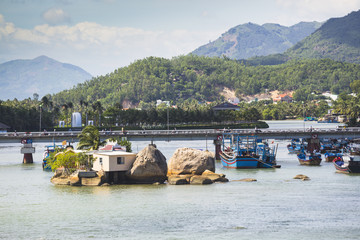 Boats and rocks near fishing village on the river Kai in Nha Tra