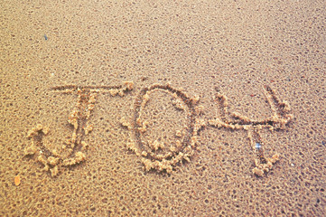 Joy word on the Sand beach at Phuket Thailand close up photo , nice background