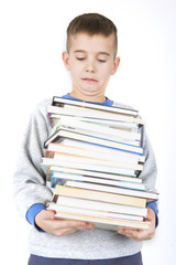 boy holding pile of books