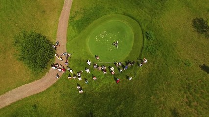 Aerial footage of a beautiful golf course with golfer making his putt