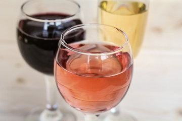 Glasses of red win and rose isolated on a wooden  background