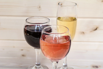 Glasses of red win and rose isolated on a wooden  background