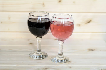 Glasses of red win and rose isolated on a wooden  background