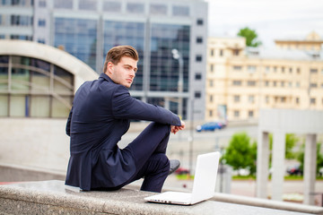 Portrait of a cheerful businessman with laptop