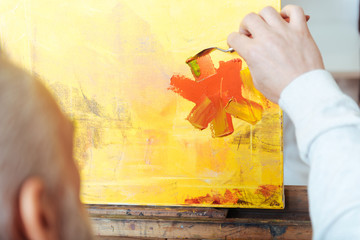 Close up of artists hands painting a picture