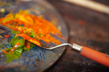Close up of a putty knife and paints