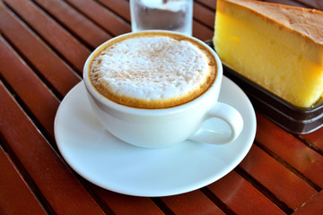 Coffee  in a cup and cake on  wooden table