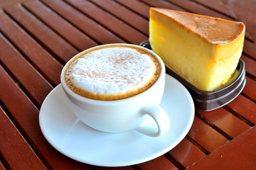 Coffee  in a cup and cake on  wooden table