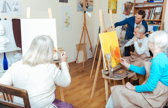 Group of people having lesson in painting school