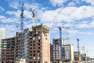 The construction of new houses on a background sky