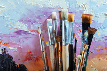 Fototapeta premium Close up of painting brushes and colorful canvas