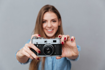 Smiling Woman in shirt making phone on retro camera
