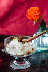 Delicious ice cream dessert in glass over black surface.