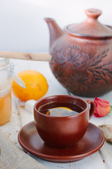 Nice ginger tea on white wooden surface.