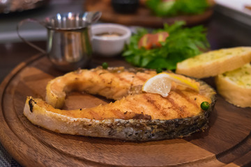 Grilled salmon steak with the fresh salad in white plate.