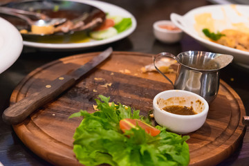 Empty wooden plate after eating pork steak. shallow focus.