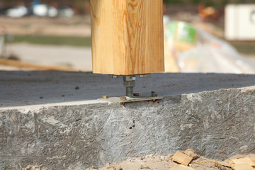 Wooden pillar on the construction site concrete with screw. Wooden Pillars are structures that can be placed on Foundations or Platforms.