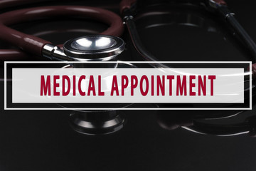 Stethoscope on black background with text MEDICAL APPOINTMENT
