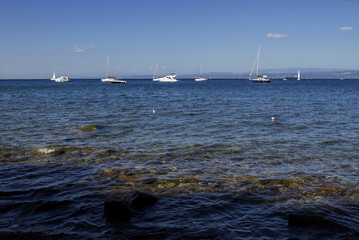 Pure water on a background of of blue sky, sailboats in a beautiful cove of the Mediterranean Sea.