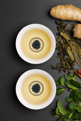 cups of tea on wooden black table, top view