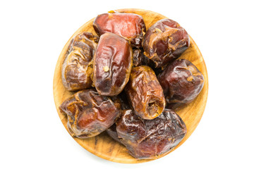 Top view of dried dates fruit in a wooden plate