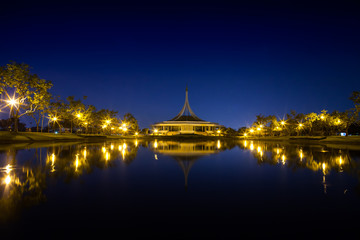 Night garden with central building landscape view reflection on water at twilight time , the garden is located at bangkok thailand