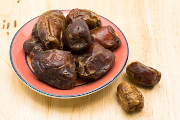 Pile of dried dates fruit in red plate