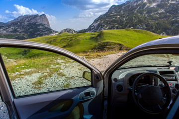 travel concept. the car with the door open on a background of mountains