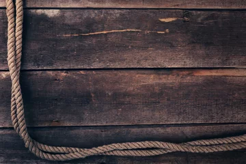 Foto op Plexiglas oud scheepstouw op houten plankachtergrond © ronstik