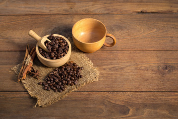Coffee cup and coffee beans on wooden background.