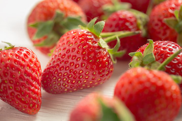 Fresh strawberries on white wooden table.