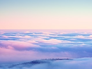 Pink orange sun rise above misty winter mountains