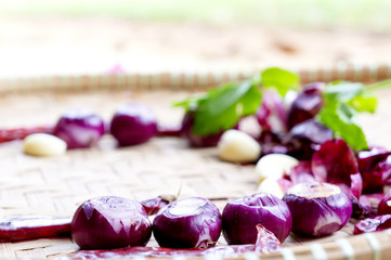 Collection of fresh onions and chilis on the bamboo matt with depth of field (DOF) effect. Top view and copy space.