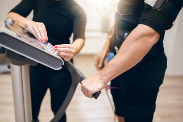 Sportsman waiting for personal trainer to turn on ems device