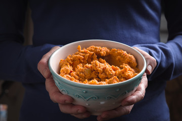 Bowl with hummus on the hands horizontal