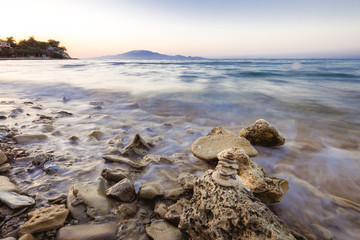 sea waves on the stone beach at sunset, long exposure landscape photo. Zakynthos, Greece