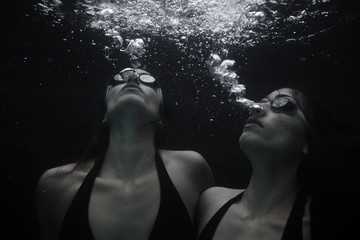 Two adult females submerged in water, close up 