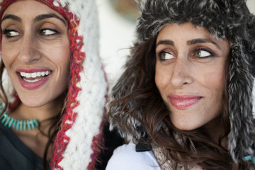 Twin adult sisters wearing winter hats with ear flaps 