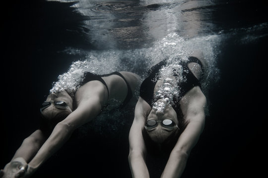 Female twins swimming underwater
