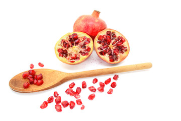 Pomegranate and two cut halves with seeds removed with spoon