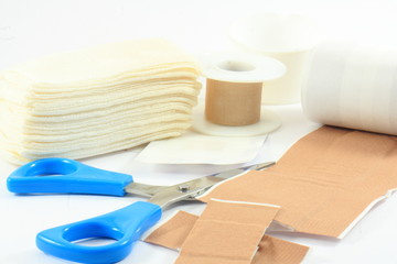 The iron scissors, bandages and plasters on a white background